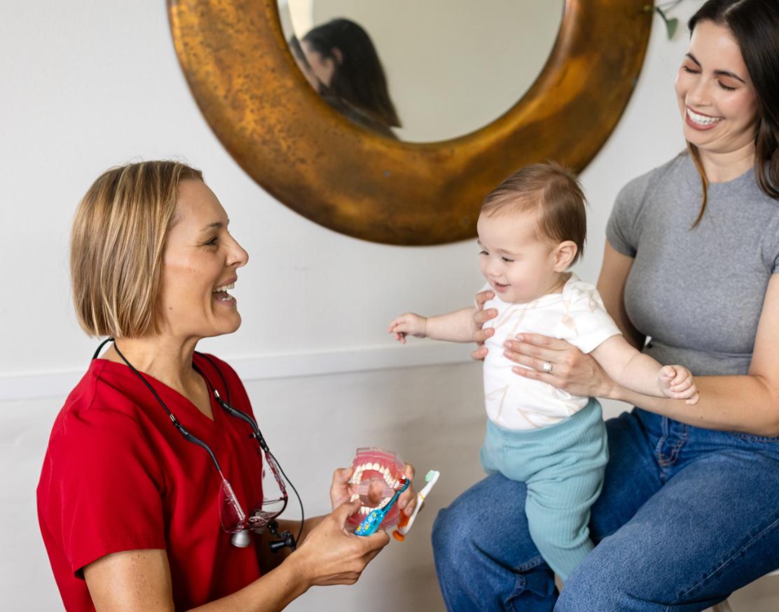 Carinne, empowering smiles health coach, interacting with mother and child
