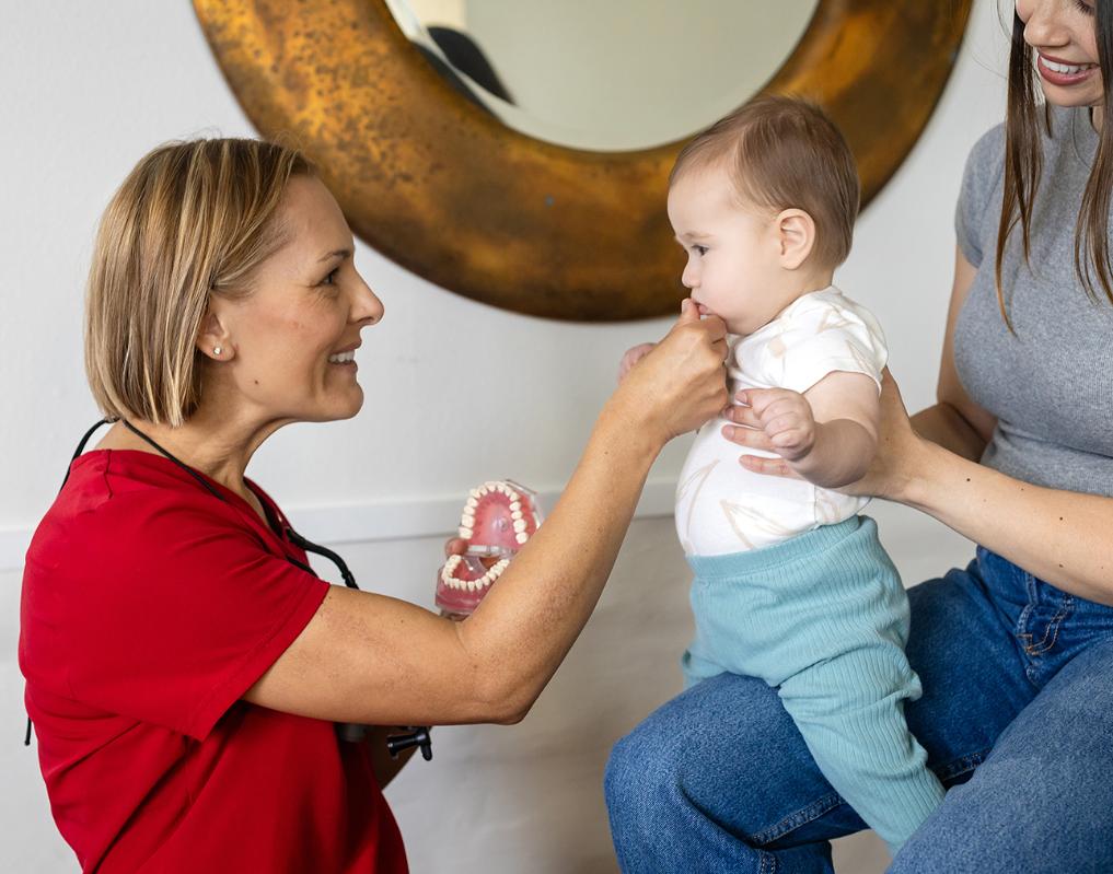 Carinne, empowering smiles health coach, interacting with mother and child