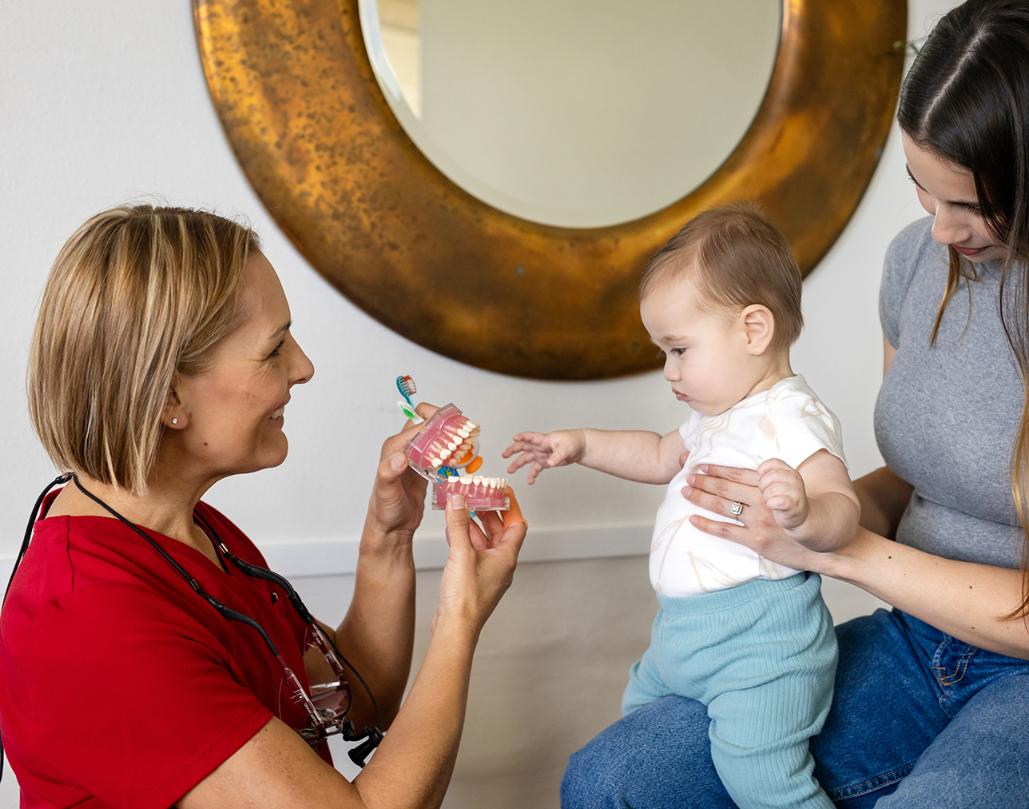 Carrine, owner of empowering smiles, interacting with young mother and baby